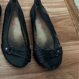 Worn black ballet flats